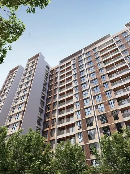 A low-angle render of the Kohinoor Uptown residential towers, framed by trees.