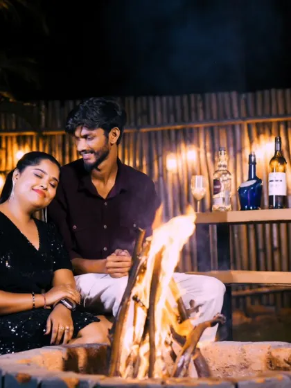 A cozy and romantic scene by a fire pit. The warm glow of the fire creates a perfect atmosphere for an intimate pre-wedding photo.