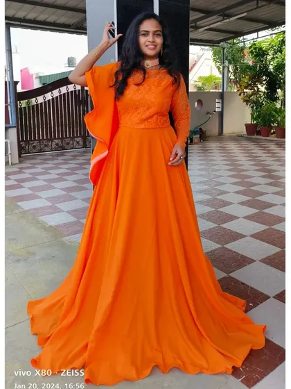 This bright orange gown is a cheerful and stylish option for your maternity shoot, featuring an embroidered bodice and a flowing skirt.