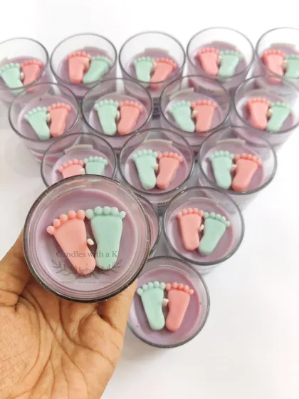 A close-up of a baby feet votive candle in a calming lilac wax, made for a corporate client, Birla Fertility & IVF Clinic.