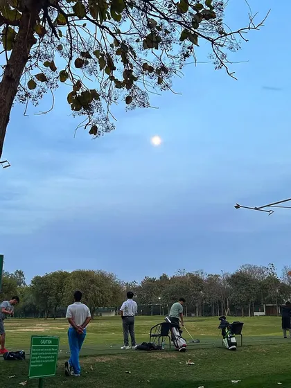 A serene evening shot with the full moon hanging over the driving range.