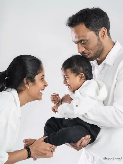 The pure, uncontainable laughter of a baby being held between his loving parents. This candid shot perfectly captures a moment of family joy.
