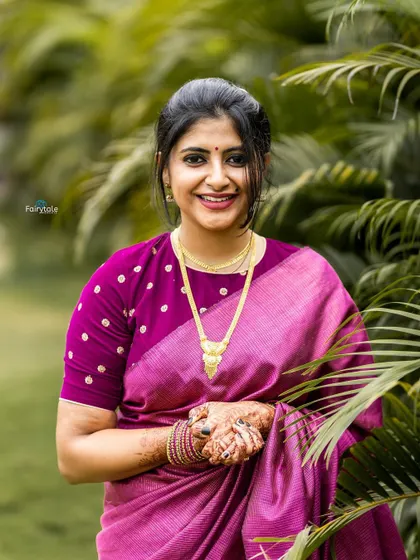 A close-up in a pink saree, smiling amidst nature. The beauty of traditional wear is enhanced by natural surroundings.