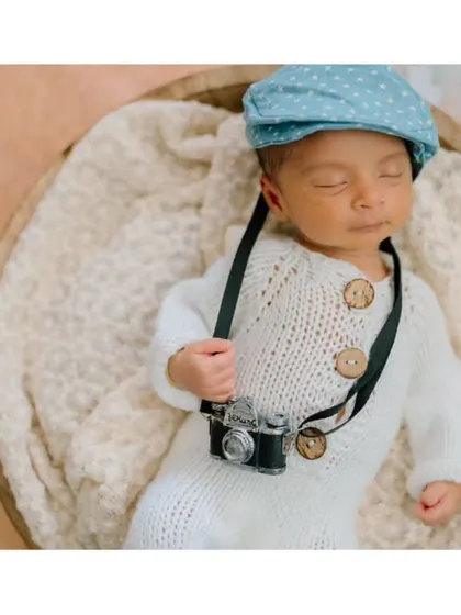 The little photographer is napping on the job! This humorous and adorable shot combines the beach theme with the camera prop.
