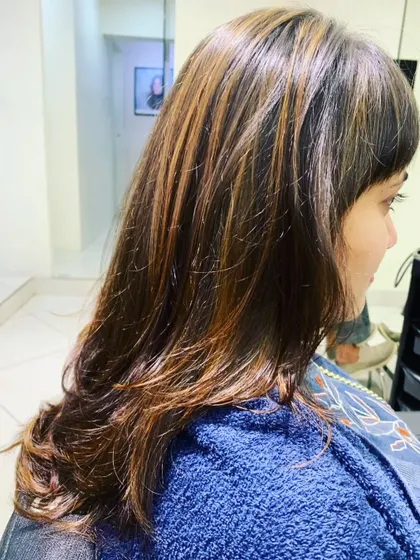 A side profile of our highlighting work. The placement ensures that the lighter pieces frame the face, brightening the client's overall complexion.
