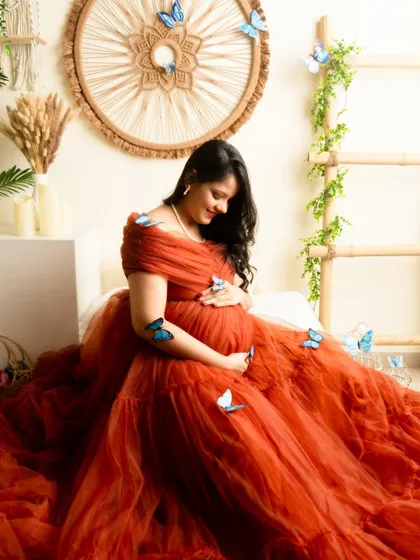 A whimsical portrait in a rust-colored gown, adorned with blue butterflies. This shot adds a touch of magic and fairytale to the session.