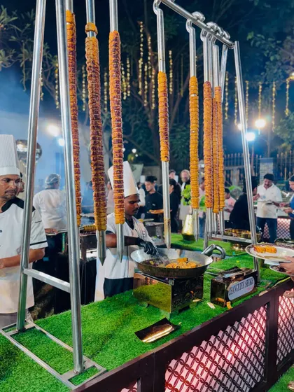 A unique presentation of seekh kebabs hanging vertically, creating a visually impressive display at the barbecue counter.