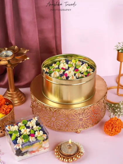 A festive sushi cake in a tin, styled with diyas and marigolds to offer a unique and modern Diwali gifting idea.