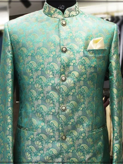 A close-up of the sea-green and gold paisley bandhgala, showing the shimmer and detail of the brocade fabric.