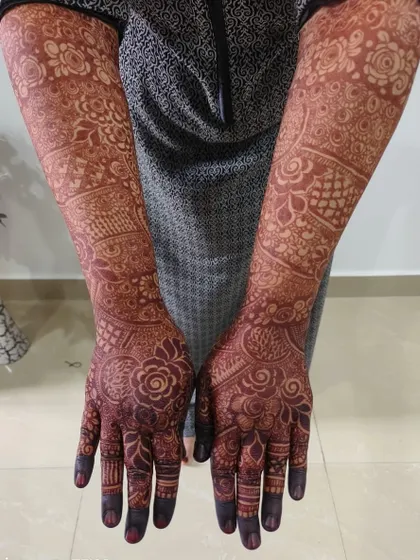 A full-arm view of a perfectly matured henna stain. You can see how the color is consistent and dark from the fingertips all the way to the elbows.