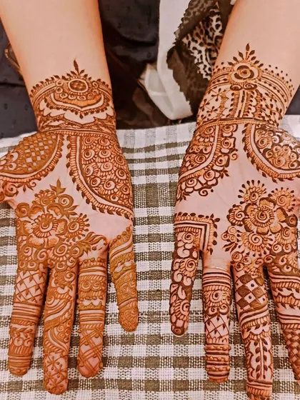 This is a lovely example of festive mehendi, perfect for Eid or Diwali. The patterns are different on each hand but share common motifs, creating a coordinated look.