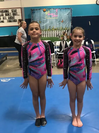 Two Bronze teammates on the floor, ready for their final meet of the season.