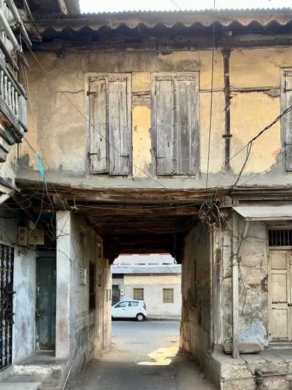 An entrance passage at Majumdar Wada in Vadodara, where the upper floor bridges the street. This image captures the integration of private dwelling and public thoroughfare, a common feature in the dense fabric of traditional Indian cities.