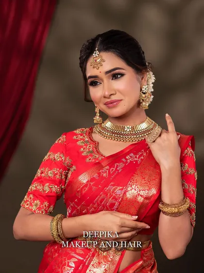 A close-up shot focusing on the bride's soft smile and the beautiful details of her choker necklace and jhumka earrings.
