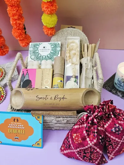 An eco-friendly and aesthetic Diwali hamper. It features a personalized bamboo speaker, incense, wax melts, and other sustainable goodies in a rustic jute basket.