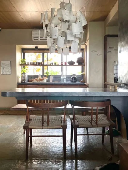 The cantilevered dining table, seen here from a different angle, is a central feature of the home. It anchors the open-plan living space and serves as a gathering point for meals and conversations.