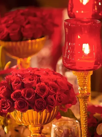 Rich red and gold decor, perfect for a luxurious wedding or Diwali celebration. The deep red roses and golden candle holders create a warm and opulent atmosphere.