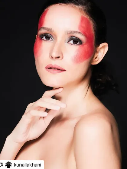 Pushing creative boundaries is a passion of mine. For this conceptual shoot, I used bold red face paint to create a graphic, monochromatic look, demonstrating my skills in artistic and avant-garde makeup for high-fashion editorials.
