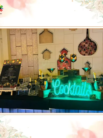 A vibrant and colorful cocktail bar setup, perfect for a lively sangeet or party. The neon sign and custom menu add to the fun and festive atmosphere.