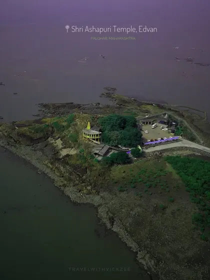An aerial view of the Shri Ashapuri Temple in Edvan, Palghar, showing the serene temple complex located on a small peninsula.