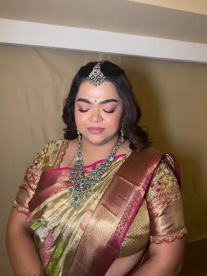 A close-up of a soft glam look on a client wearing a traditional saree. The pink eyeshadow and dewy skin create a fresh and youthful appearance, perfect for a bridesmaid or wedding guest.