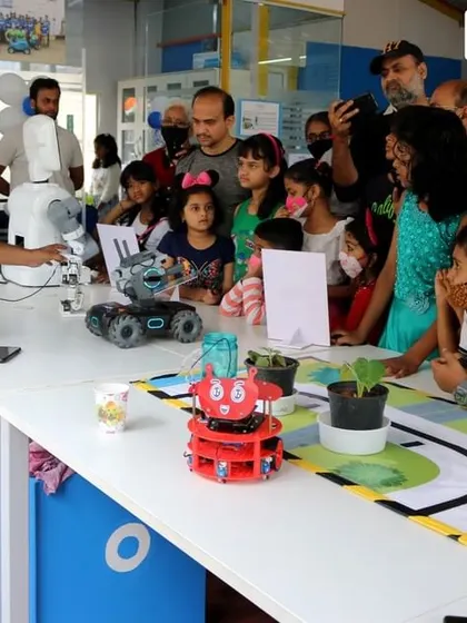An instructor demonstrates a robot's capabilities to an excited group of kids and parents at a RoboExpo. These events are a great way for the community to experience the magic of robotics firsthand.