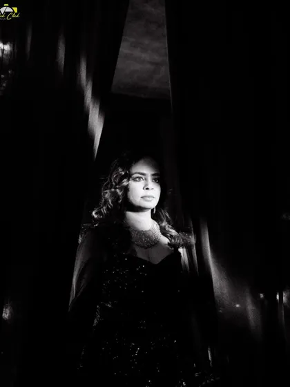 A stunning black and white portrait of Komal, using dramatic lighting to create a moment of quiet elegance before the party began.