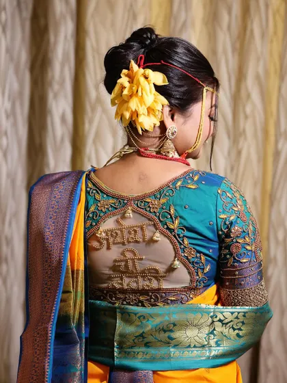 This image showcases a unique and personalized blouse design with the phrase 'Aai Baba'. It's a beautiful example of how modern trends can be woven into traditional wedding attire.