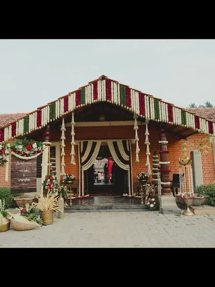 The entrance to a traditional South Indian home, decorated for a wedding. We used classic elements like floral thorans on the roofline and brass lamps to enhance the venue's inherent beauty and cultural significance.