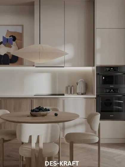 A close-up of the kitchen and dining area, highlighting the integrated ovens and the simple, elegant lines of the furniture.