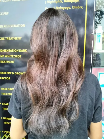 The final result of a new hair color, looking soft, wavy, and beautifully blended.