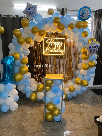 A clear view of the baby boy's first birthday setup, including a plinth for the cake.