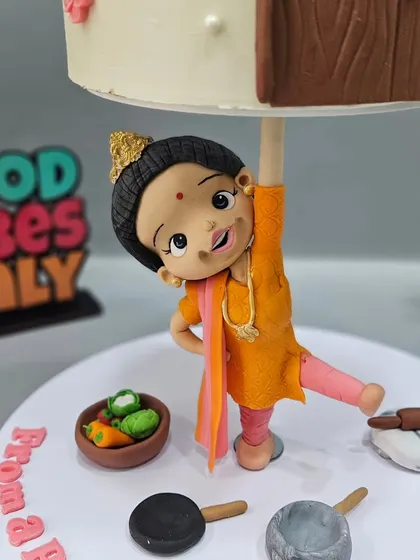 The strong 'nani' figurine holding up the cake, showcasing the story of a grandmother's strength.