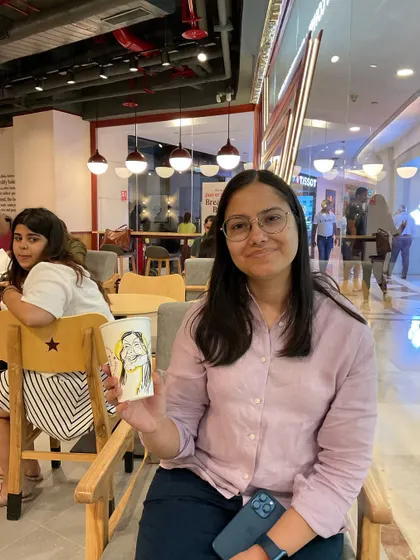 A happy customer with her personalized coffee cup art.