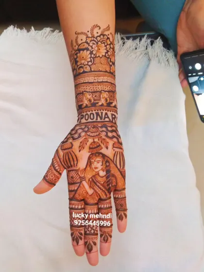 A clear, still shot of the personalized bridal hand with the name 'POONAM' and elephant motifs. A perfect way to make your mehndi your own.