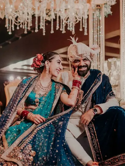 A vibrant, joyful moment from a Pune wedding. The bride's playful touch and the couple's happy expressions perfectly capture the celebratory mood.