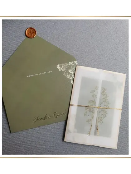 The complete olive green suite, including the envelope with gold foil details and the vellum-wrapped inserts.