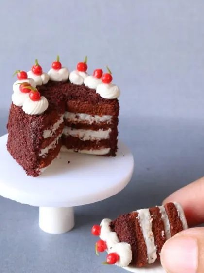 A close-up of a miniature red velvet cake with a slice taken out, showing the beautiful layers inside.