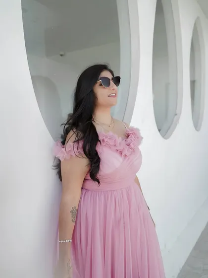 A client looking chic in a custom pink ruffled gown, perfect for a vacation or pre-wedding shoot.