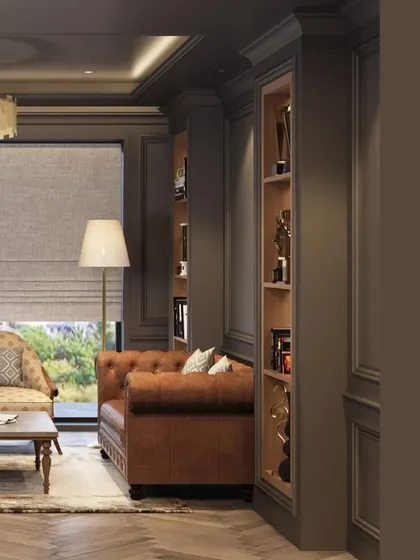 A detail shot of the office lounge area, showing a classic brown leather sofa and built-in shelving for awards and books. The design uses rich textures and a sophisticated color scheme to create a warm and inviting atmosphere.