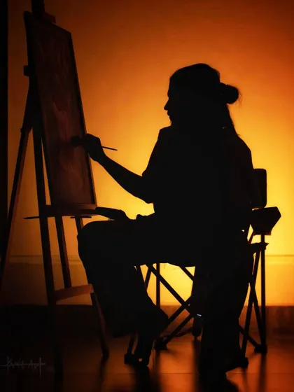 "Let Art Get you through the Dark." A silhouette of an artist at the easel, capturing the focus and dedication that goes into every piece.