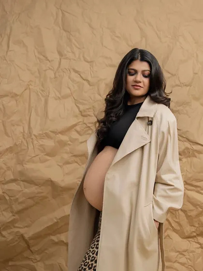 Fearless and fashionable. Pairing a classic trench coat with leopard print pants and a bare bump is a bold statement. It redefines maternity style, showing that you can be powerful and chic.
