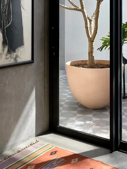 Sunlight casts beautiful shadows across the floor in this passage overlooking a courtyard in the Mango Orchard House, demonstrating our focus on natural light architecture.