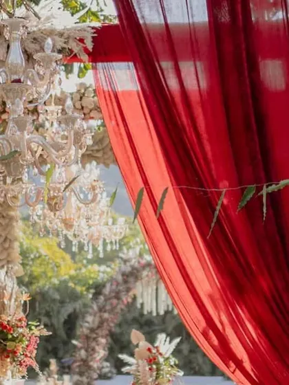 A close-up of the rich textures in our Sabyasachi-inspired decor. The deep red drapes provided a dramatic contrast to the intricate floral and pampas grass arrangements.