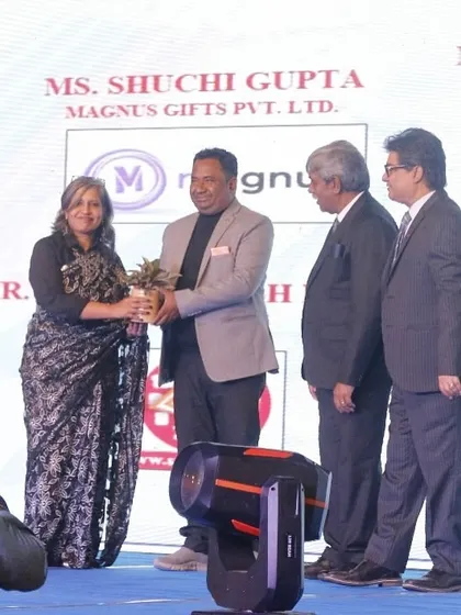 A guest is felicitated with a plant, a gesture of our commitment to sustainability, during the fashion show.