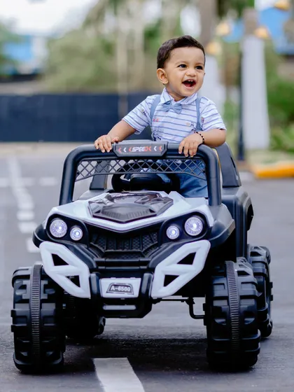 A duplicate of image 65, capturing the pure joy of a little boy in his toy jeep during his birthday photoshoot.