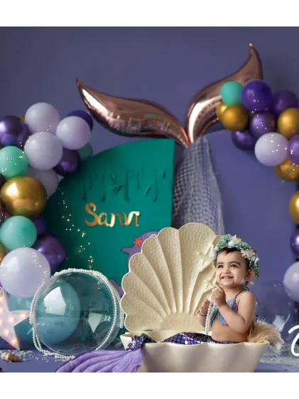 A happy little mermaid in her grotto. Our underwater-themed set is complete with a balloon arch, pearls, and a custom nameplate for a personalized touch.