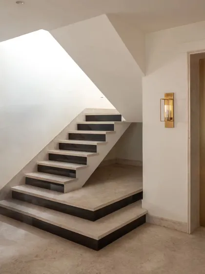 Staircases are often overlooked but are one of the most used parts of a home. This minimalist staircase is a design detail in itself, with its clean lines and the contrast between the light stone steps and dark risers.