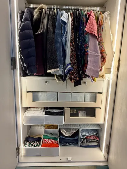 This image shows a variety of storage solutions within one closet, including hanging space, open-front bins, and pull-out drawers, all working together in harmony.