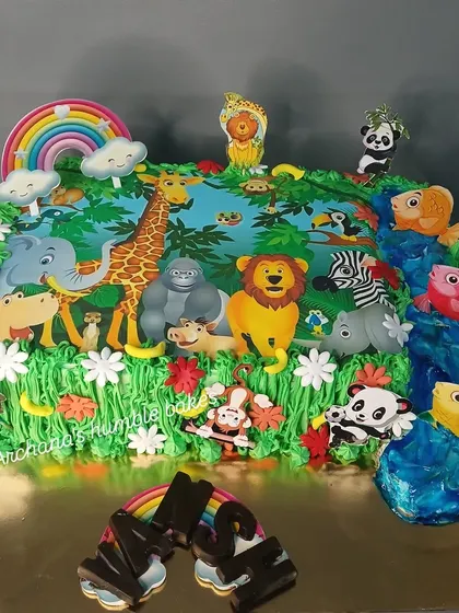 A grand jungle-themed cake with a whole host of animals, a waterfall, and a rainbow. This large sheet cake is great for bigger parties.